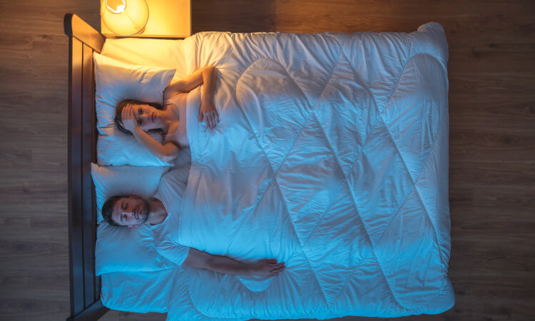 couple in bed woman can't sleep