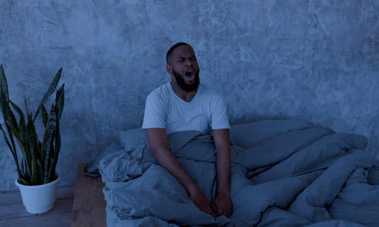 man in bed yawning